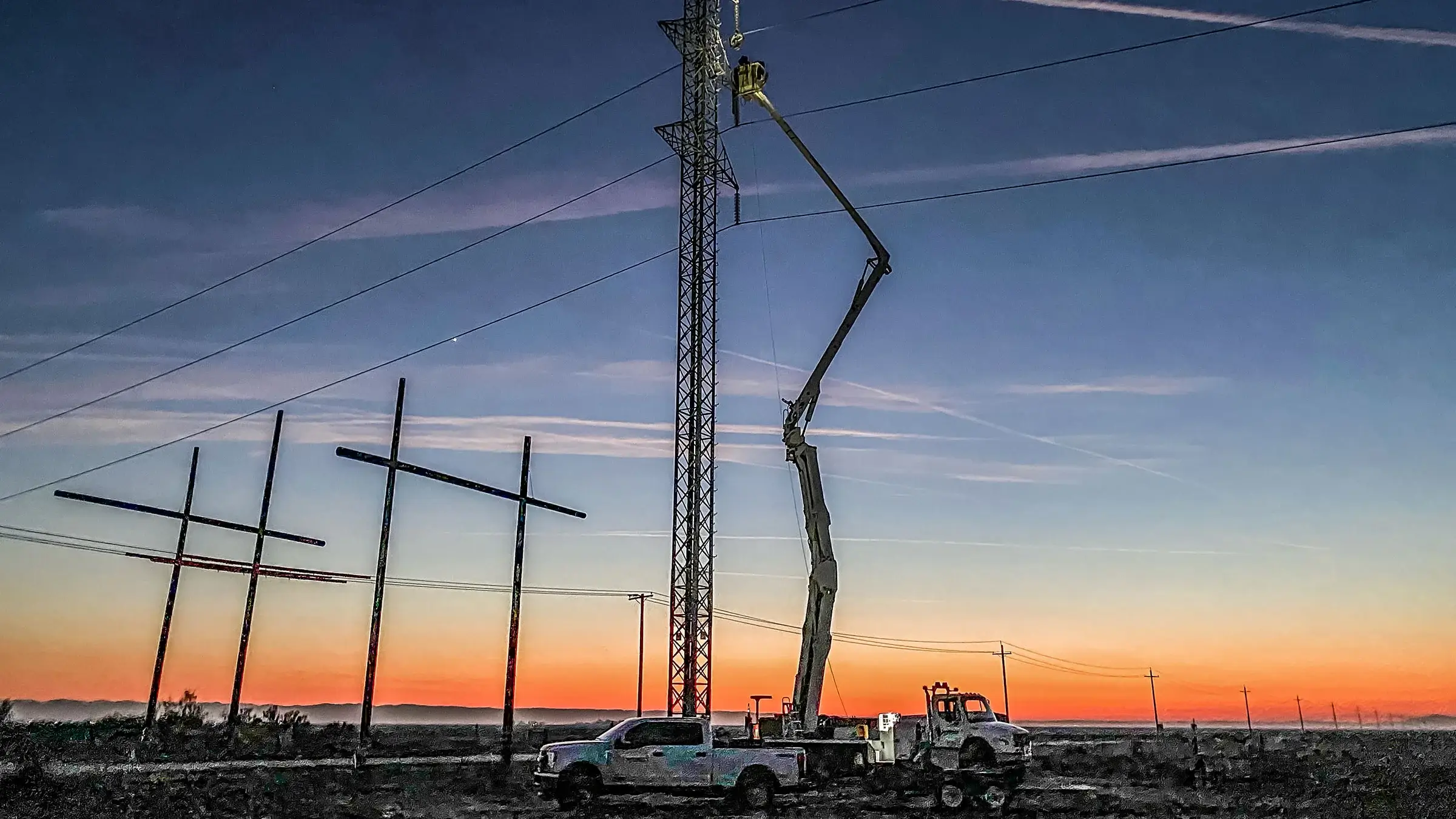 A bucket truck operates at dusk